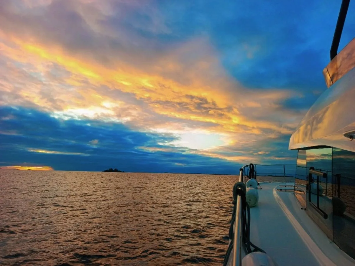 Sunset reflected across the water beside a Placencia Yacht Charters yacht