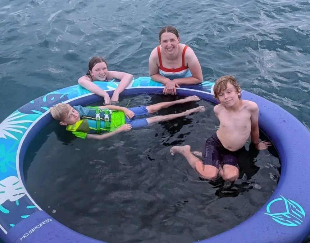 Family enjoying the water beside their yacht