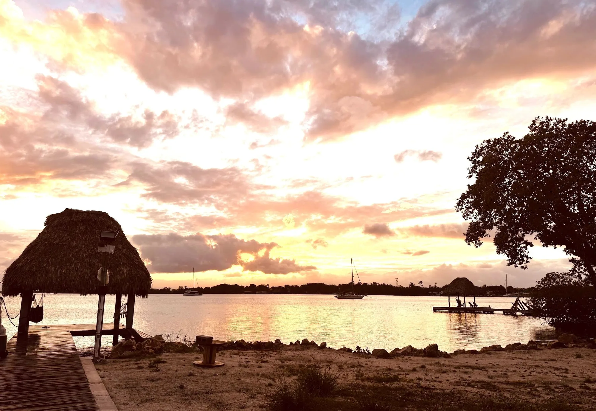 Belize sunset behind a palm-thatched palapa
