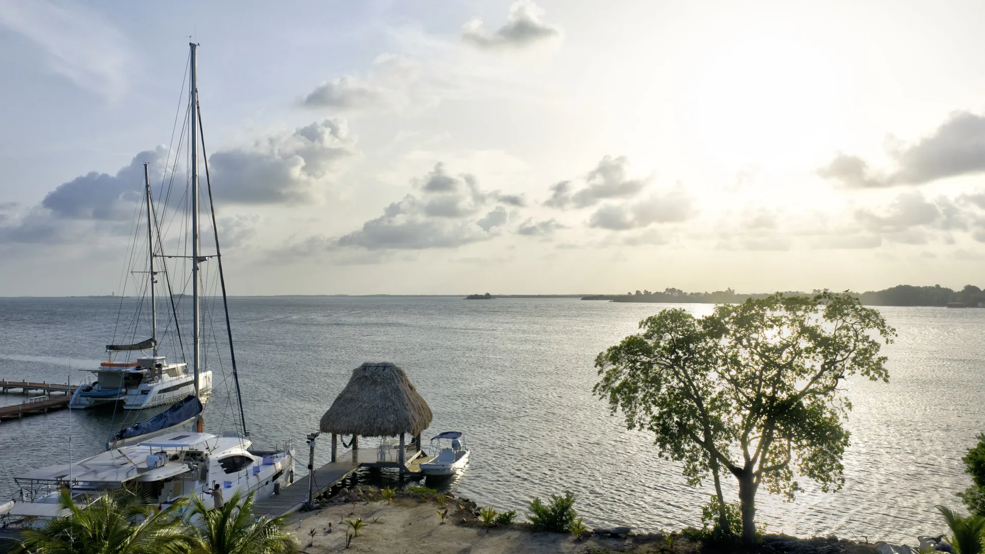 Sailing yachts beside a waterfront palapa in Placencia