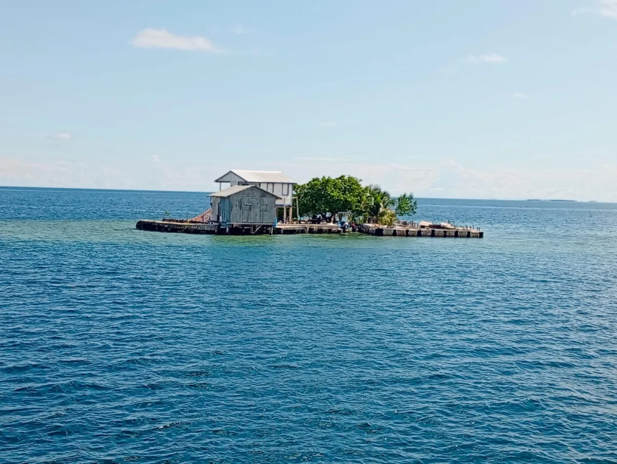 Small tropical caye surrounded by clear blue water